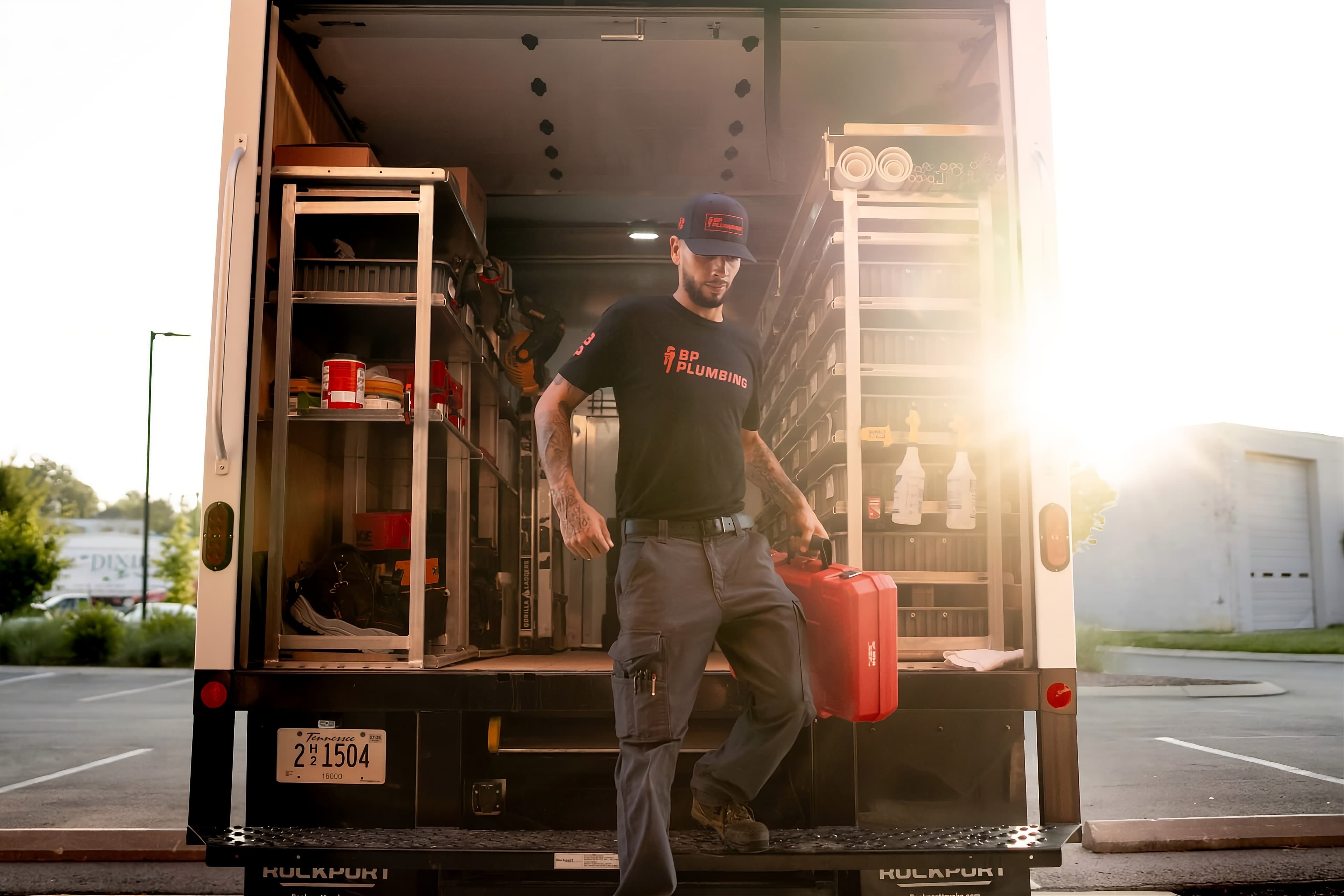 A BP Plumbing technician stepping down from the company truck at sunset in Chattanooga