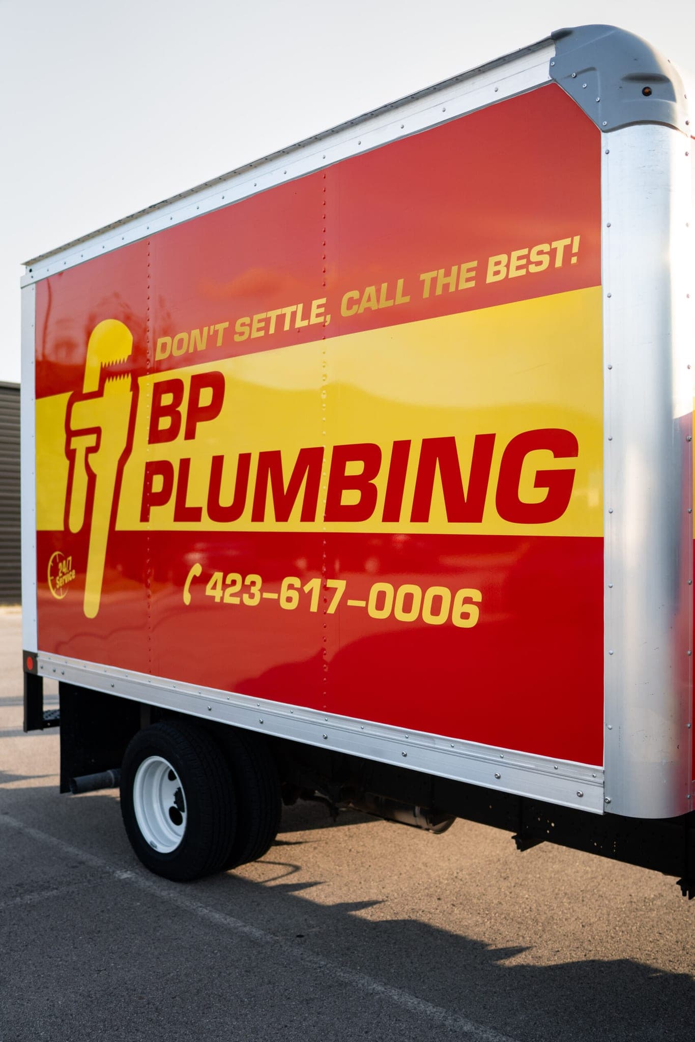 The BP Plumbing truck, lettered with the company name and phone number